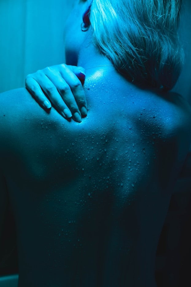 Sweating helps remove toxins from the woman’s body in a SaunaCoreInfraredSauna.