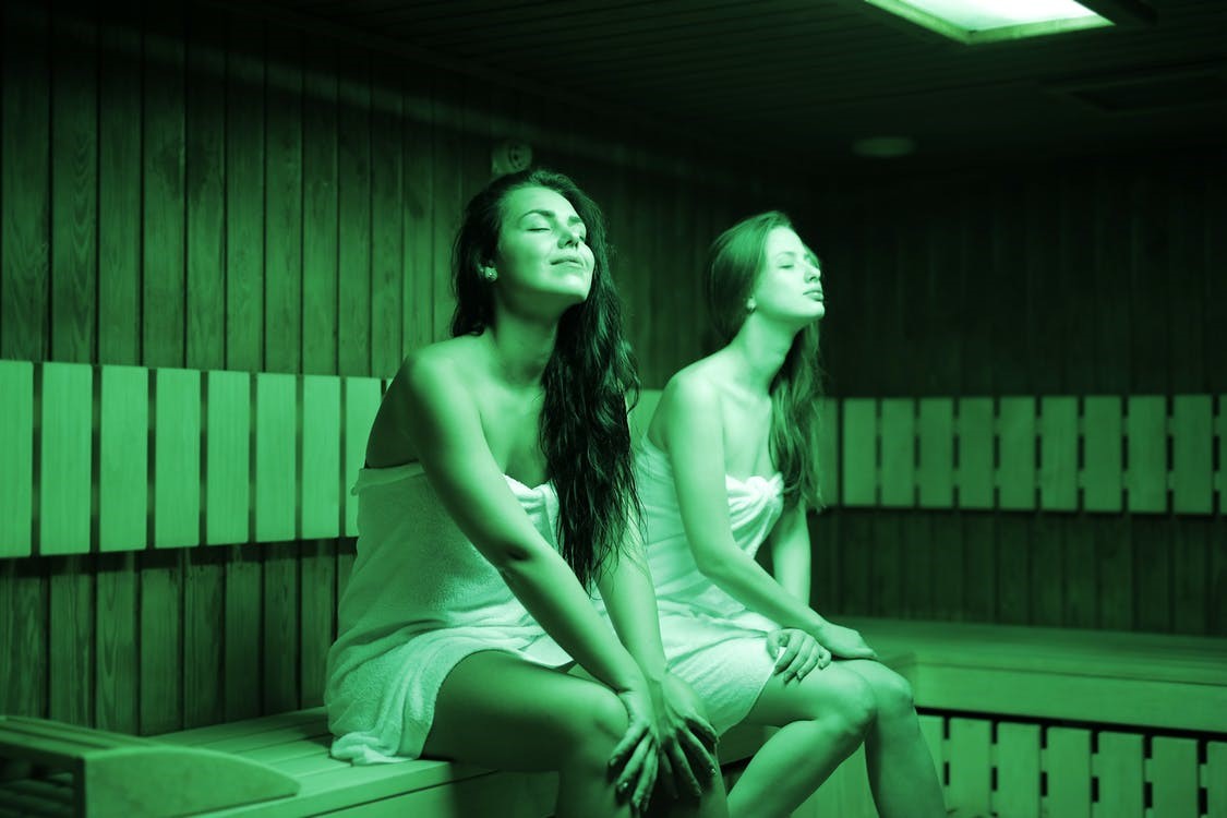 Two women enjoying a relaxing infrared sauna session at home.