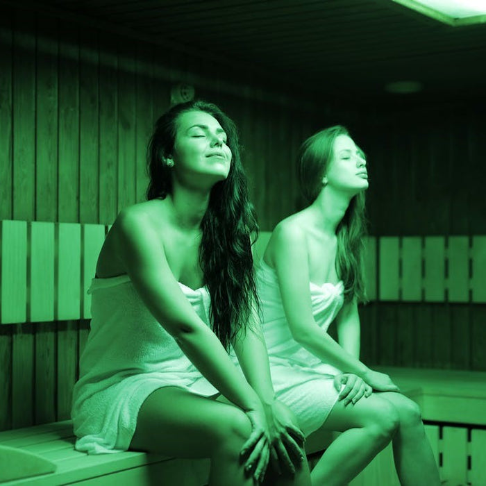 Two women enjoying a relaxing infrared sauna session at home.