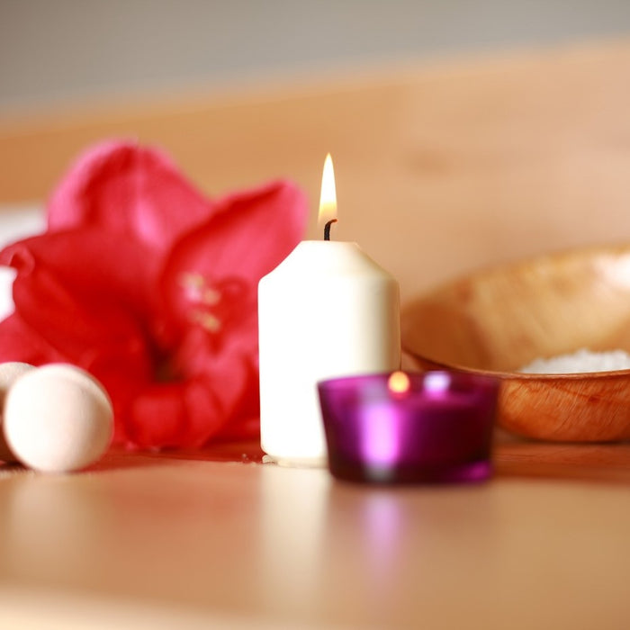 An aesthetic collection of soothing items, including scented candles, bath salts, and flowers