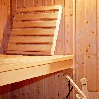 Wooden bench and bucket inside a sauna room